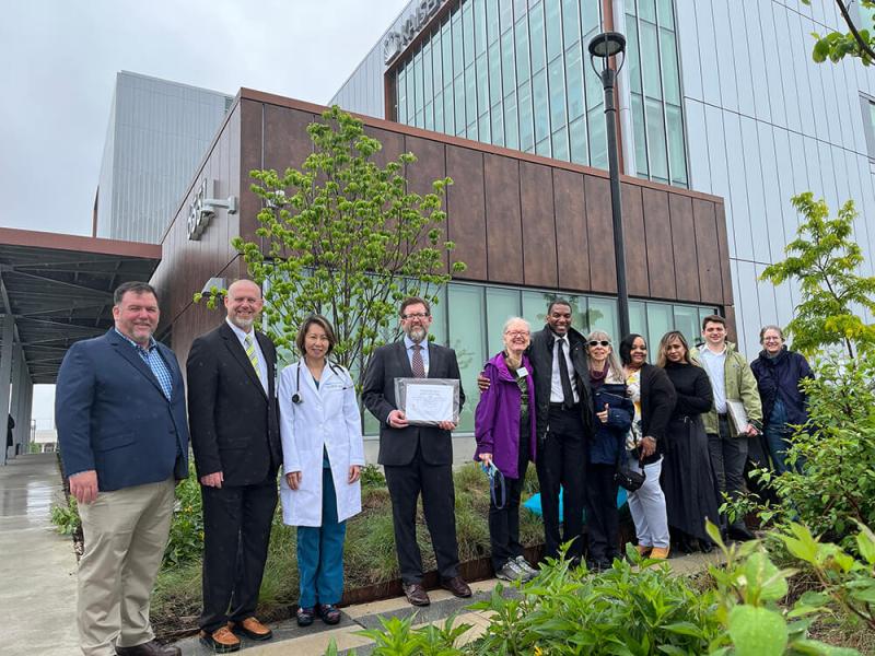 Group photo in front of the Kaiser Permanente Building in Springfield - L to R: Brian Keightley, Bob Duggan, Esther Bahk, Brent Roberts, Cindy Speas, Supervisor Lusk, Glenna Tinney, Seguira Taylor, Sumrien Ali, Nick Letteri, and Margaret Fisher.