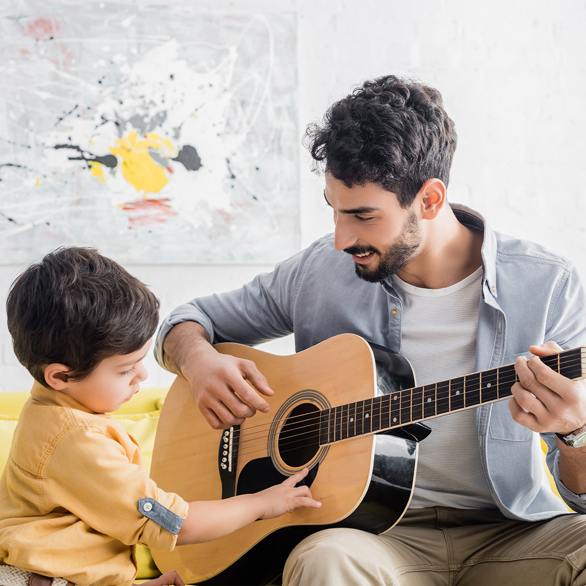 dad playing guitar with son