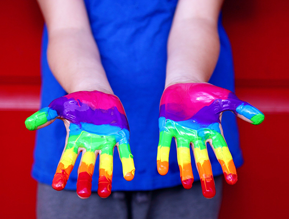 child hands painted with rianbow