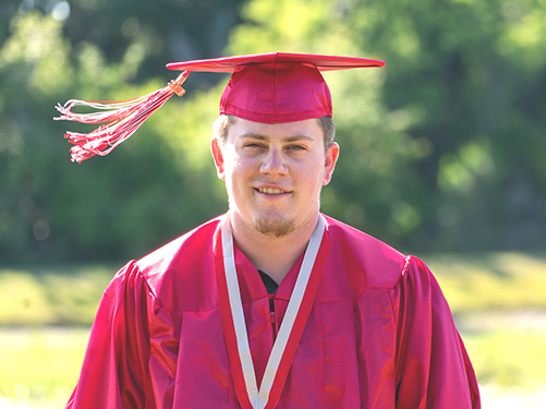 graduate with maroon cap and gown 