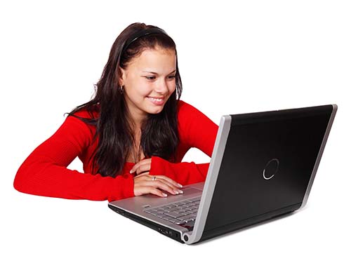 person smiling and sitting using laptop
