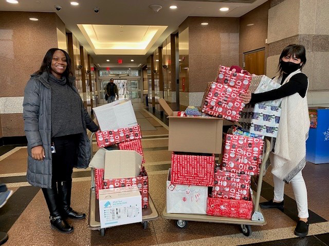 : DFS staff Arrika Watkins and Francesca Lovitt receive baby boxes provided by our generous donors, Denise Gavilan, the Kids Giving Back organization, and the knitting club in Annandale.