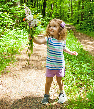 child holding wildflowers