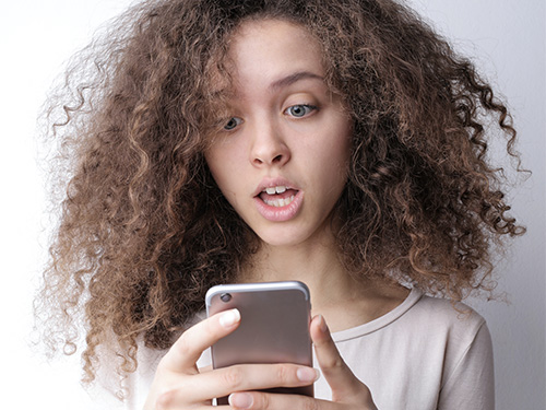 girl surprised holding phone