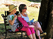 two women sitting on park bench
