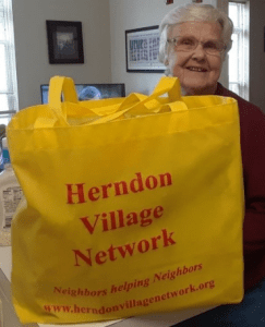 A resident receives groceries from Herndon Village Network