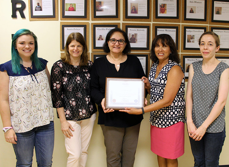 Four Bright Horizons staff members accept a certificate of recognition from Christine Carlock