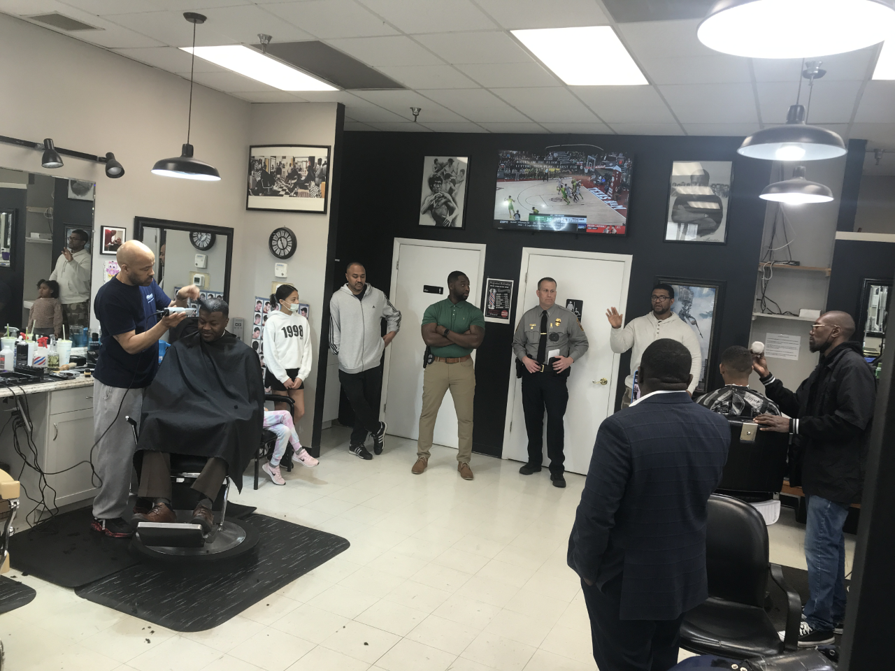 Man talking in a barber shop and people listening to him