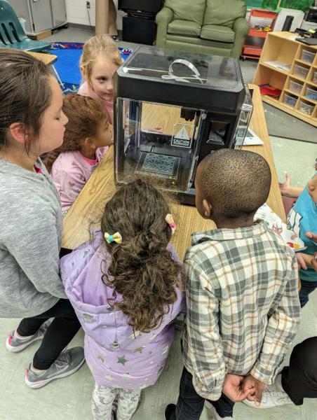 Photo of children looking into 3D printer