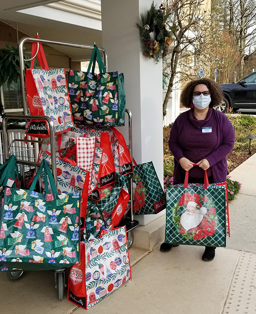 Photo of a staff member accepting gift bags for residents at Tall Oaks Assisted Living Center.