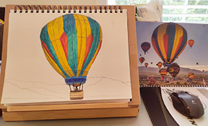 Photo showing a painting of an air balloon and the photo it based on