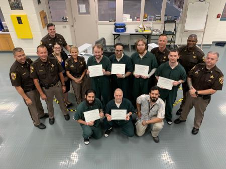 Sheriff Kincaid, staff, Nick Yacoub and inmates holding certificates