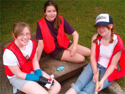three girls with a labeled storm drain