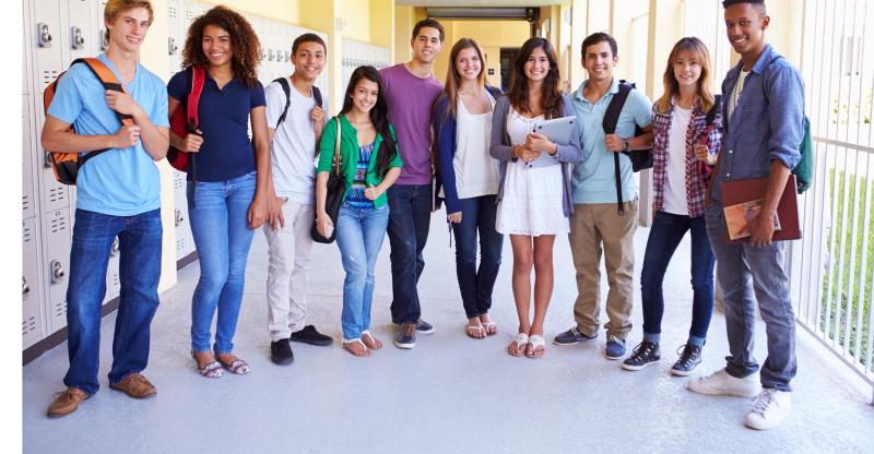 Kids in high school standing around with backpacks