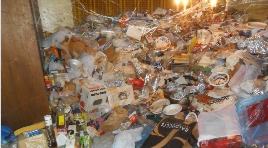 Trash and spider webs fill room