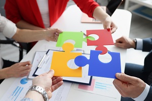 people holding puzzle pieces