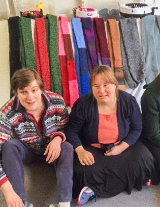 Photo of two women in front of colorful scarves