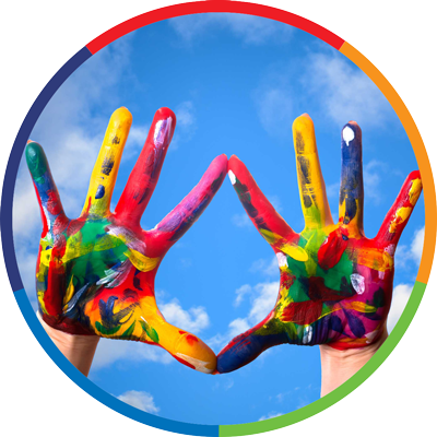Two hands covered in multiple colors of paint held up to the sky.