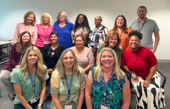 Fifteen people who are part of CSB's Human Resources team sit and stand together.