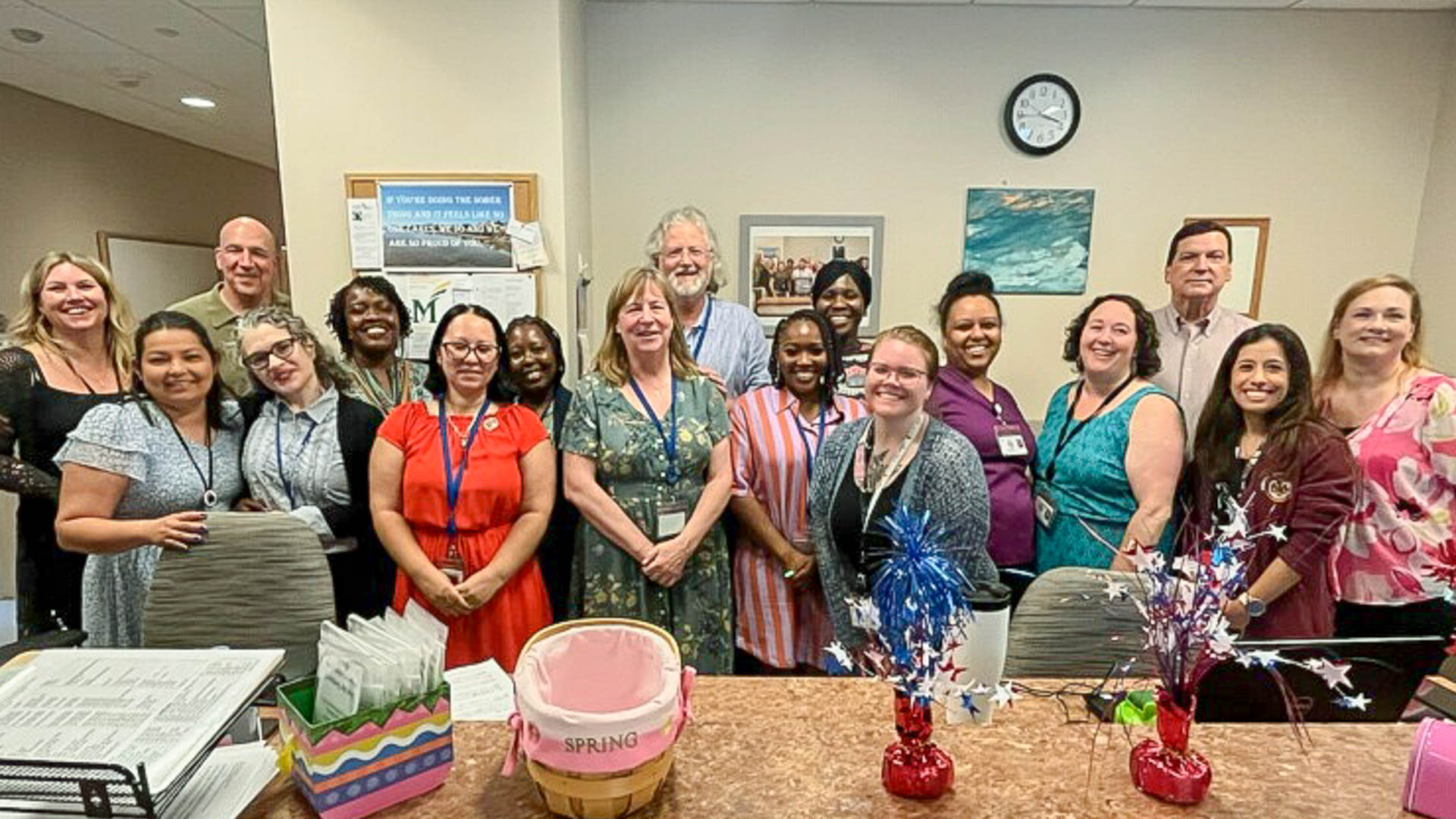 a group of men and women pose for a group picture in a medical clinic waiting room