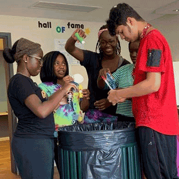 Photo of teens cleaning up after a painting project
