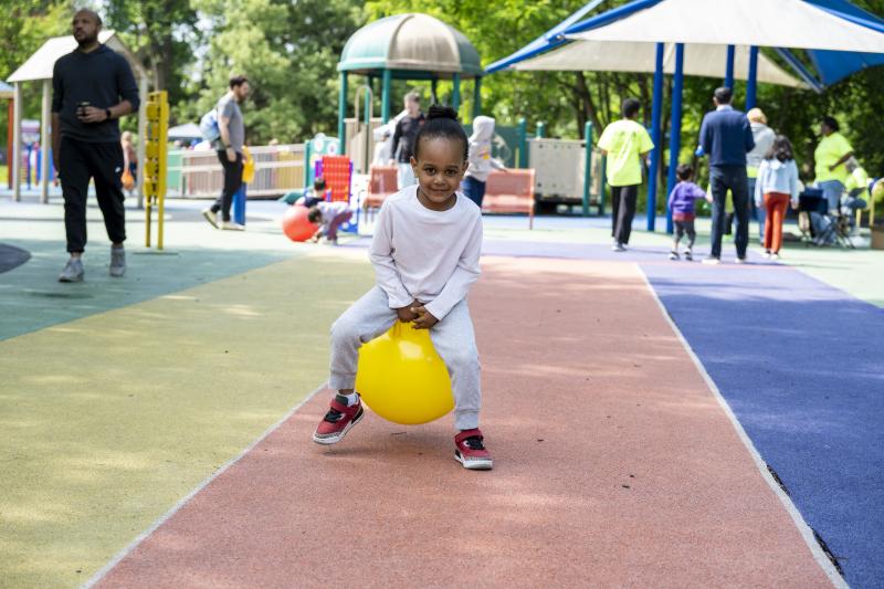 A child bounces on a yellow ball at Clemyjontri Park at the Children's Mental Health event