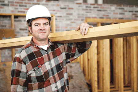 Photo of man carrying lumber on a construction project