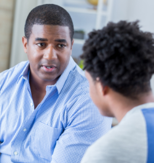 Photo of father talking with teen son