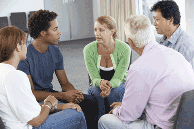 Photo of people sitting in a circle talking