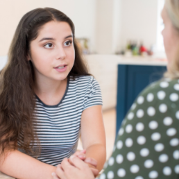 Photo of teen daughter talking with mother