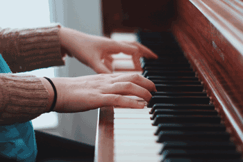 Photo of person's hands playing piano