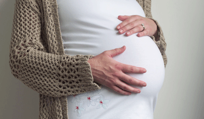 Photo of pregnant woman with her hands on belly