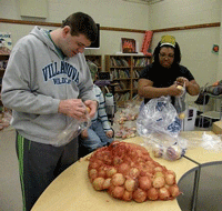 Photo of young man and woman with developmental disability bagging onions