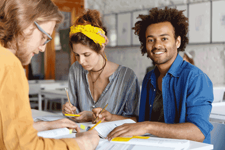 Photo of three adults studying together