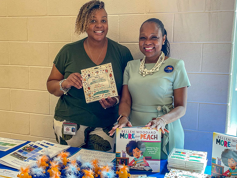 staff from the CSB standing at a table with books and other materials for kids