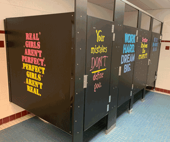 Photo of school bathroom stalls painted with positive messages
