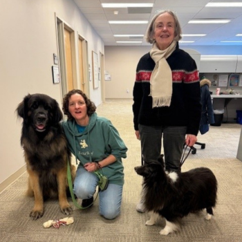 Two VIVA! volunteers pose with two large dogs during Love and Lattes event.