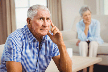 Photo of senior man with wife in background