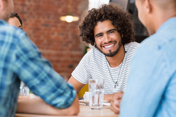 Photo of smiling young man with friends