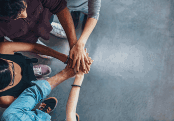 Photo of young people from above, stacking hands on top of each others'