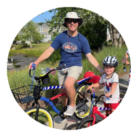 man on bike next to child on bike