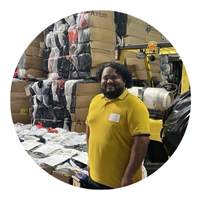 carlos leieva headshot, a man with a yellow shirt in a textile recycling warehouse