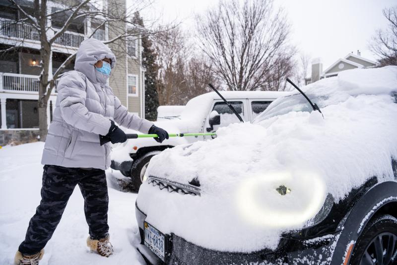 person clearing snow off their car