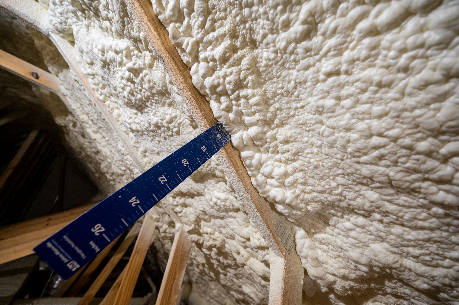 a photo of insulation in an attic with a ruler showing almost 16 inches