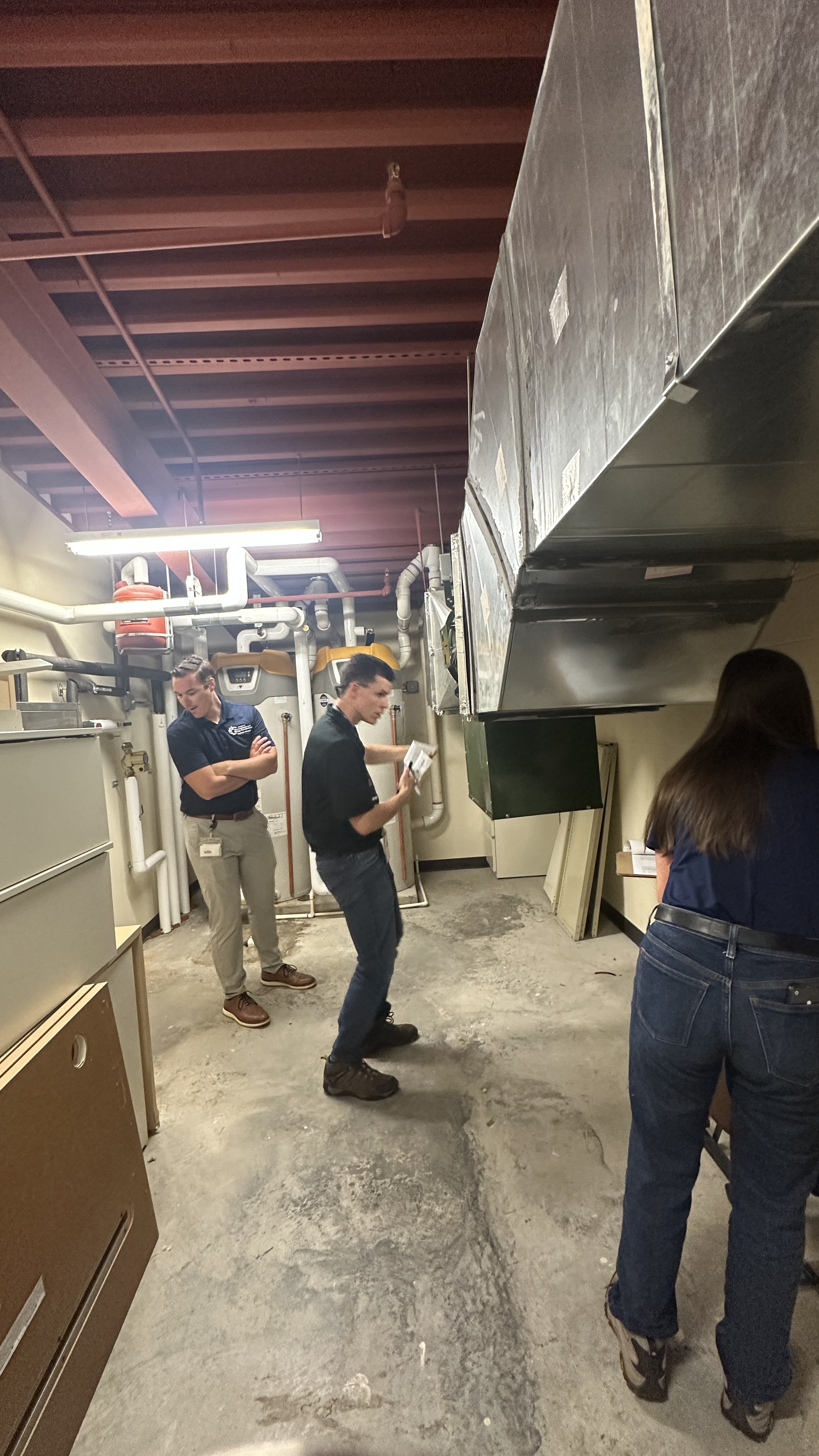 man looking at silver duct work