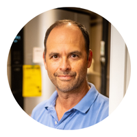 headshot of a man in a blue collared shirt