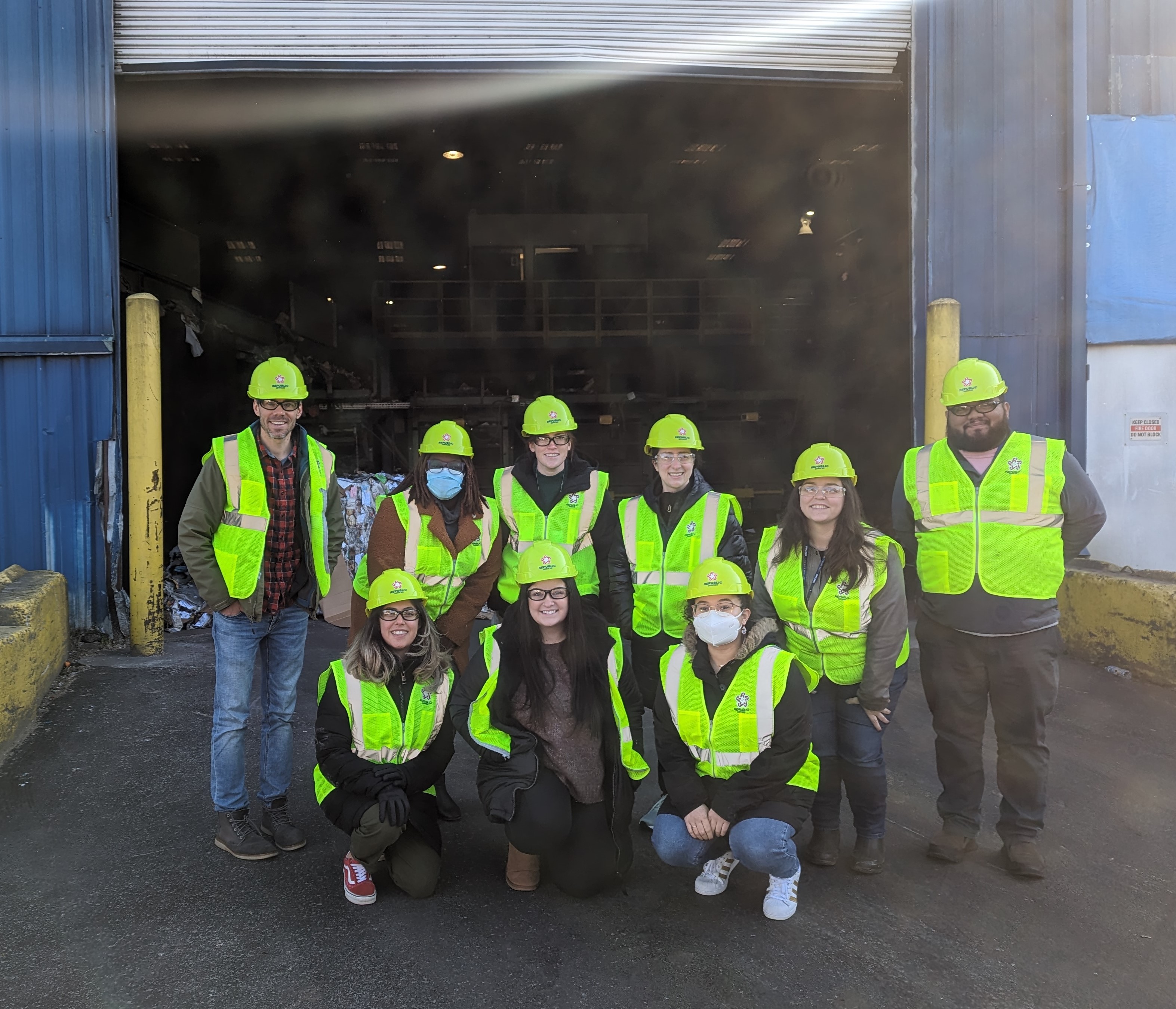 group of FEEE members in neon vests at a recycling center