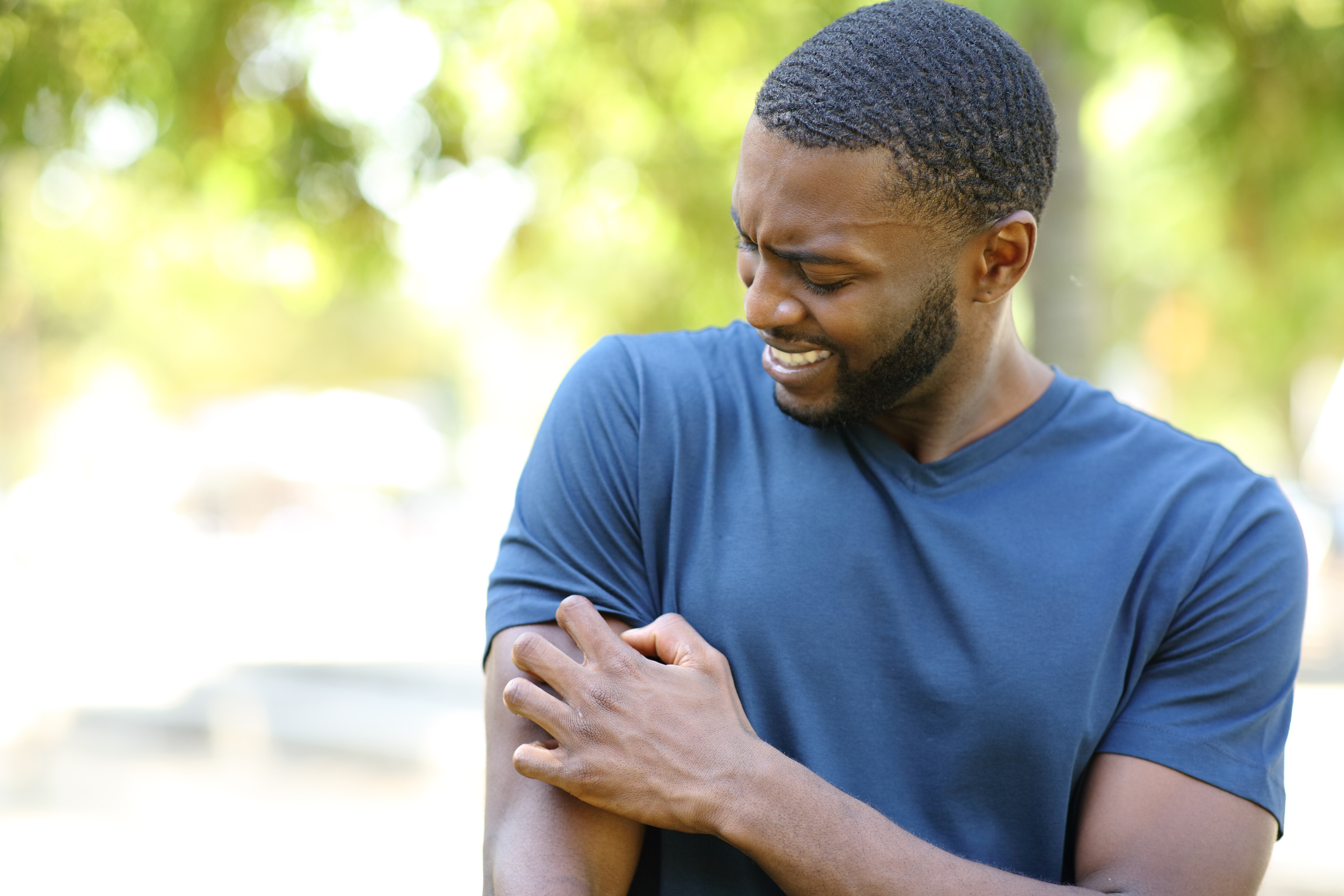 man scratching a bug bite