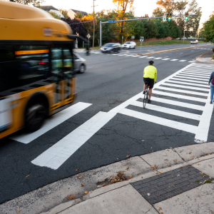 person in bright yellow biking through intersection