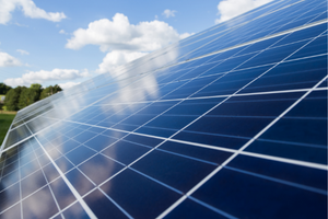 photo of a solar panel with clouds reflecting